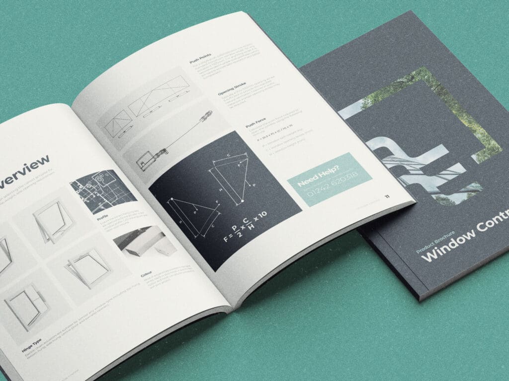 Two open brochures on a green surface: one displays technical drawings and text, the other shows architectural images and 