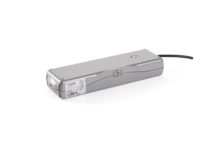 A rectangular metallic device with a label, a small circular port, and a black cable extending from one end, often used in door automation systems.