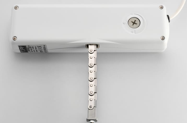 White rectangular electronic device with a metal extension arm and a screw on the top surface, designed to integrate seamlessly with door automation systems.