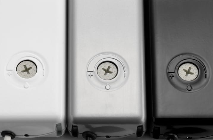 Three battery compartments with visible screw closures are shown side by side in white, silver, and black colors. These compartments can be integrated into smoke ventilation systems for enhanced safety.